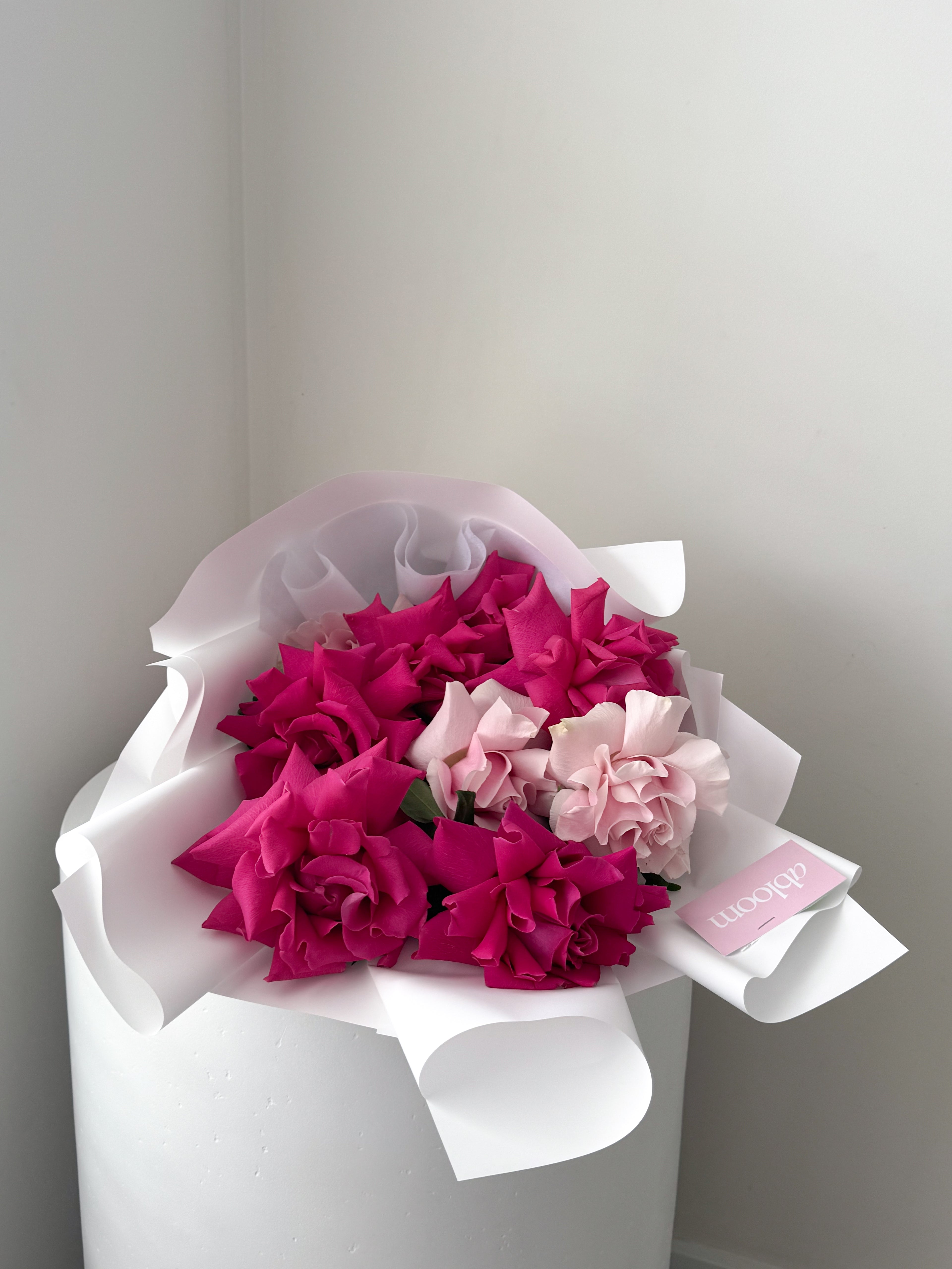 Abloom vibrant pink and light pink bouquet featuring reflexed roses, wrapped in white Korean-style paper with pink ribbon – Melbourne flower delivery - melbourne florist - melbourne reflexed roses - pink floyd roses and pink mondial roses reflexed